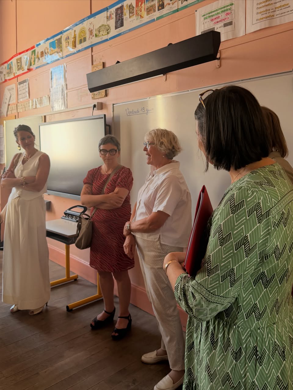 Paulette Matray dans une salle de classe de l’école élémentaire Est de Chalon-sur-Saône, échangeant debout avec des responsables de l’Éducation nationale