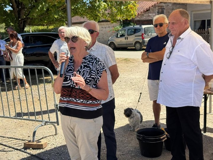 Paulette Matray prend la parole au micro en plein air, au concours de chevaux de trait de Lalheue, entourée d’élus et d’organisateurs