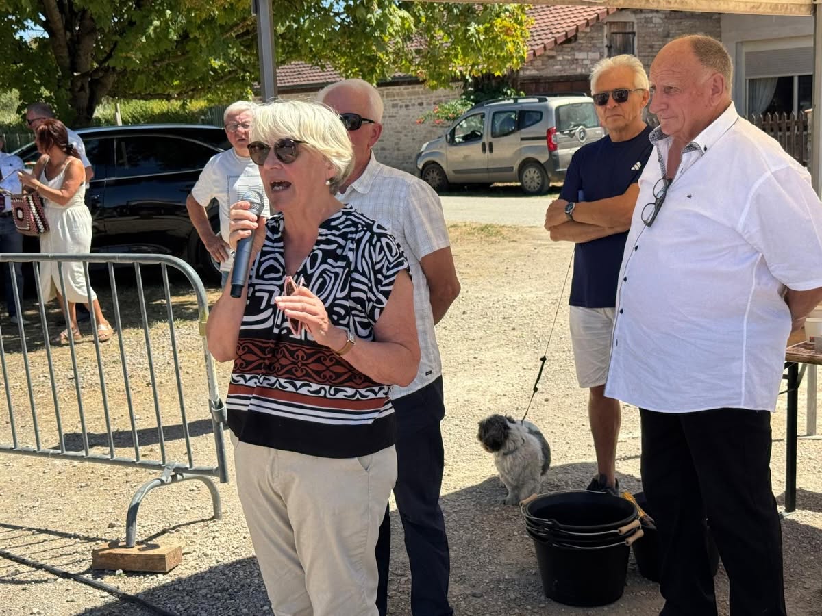 Paulette Matray prend la parole au micro en plein air, au concours de chevaux de trait de Lalheue, entourée d’élus et d’organisateurs