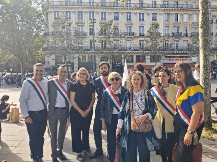 Paulette Matray, ceinte de son écharpe tricolore, pose avec d’autres élus en écharpe sur une place parisienne