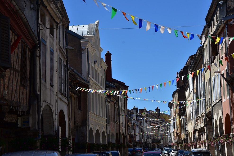 La Grande Rue de Louhans, ses arcades et ses commerces, sous des guirlandes de fanions colorés