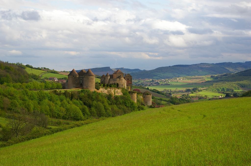 La forteresse de Berzé-le-Châtel et ses tours rondes, dominant une vallée verdoyante du Mâconnais