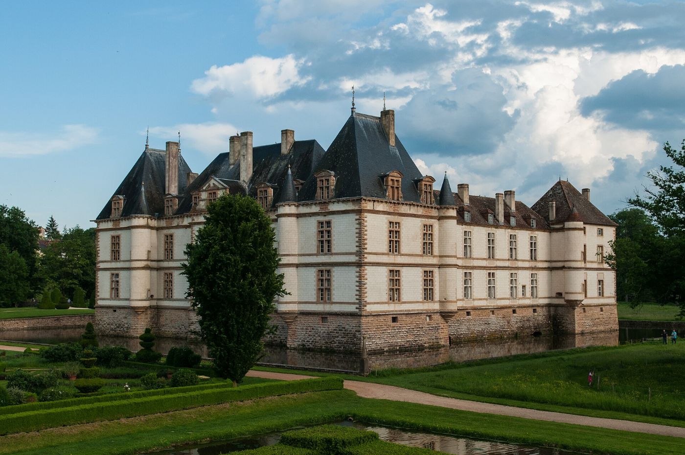 Le château de Cormatin, ses toits d’ardoise et ses douves, vu depuis ses jardins à la française