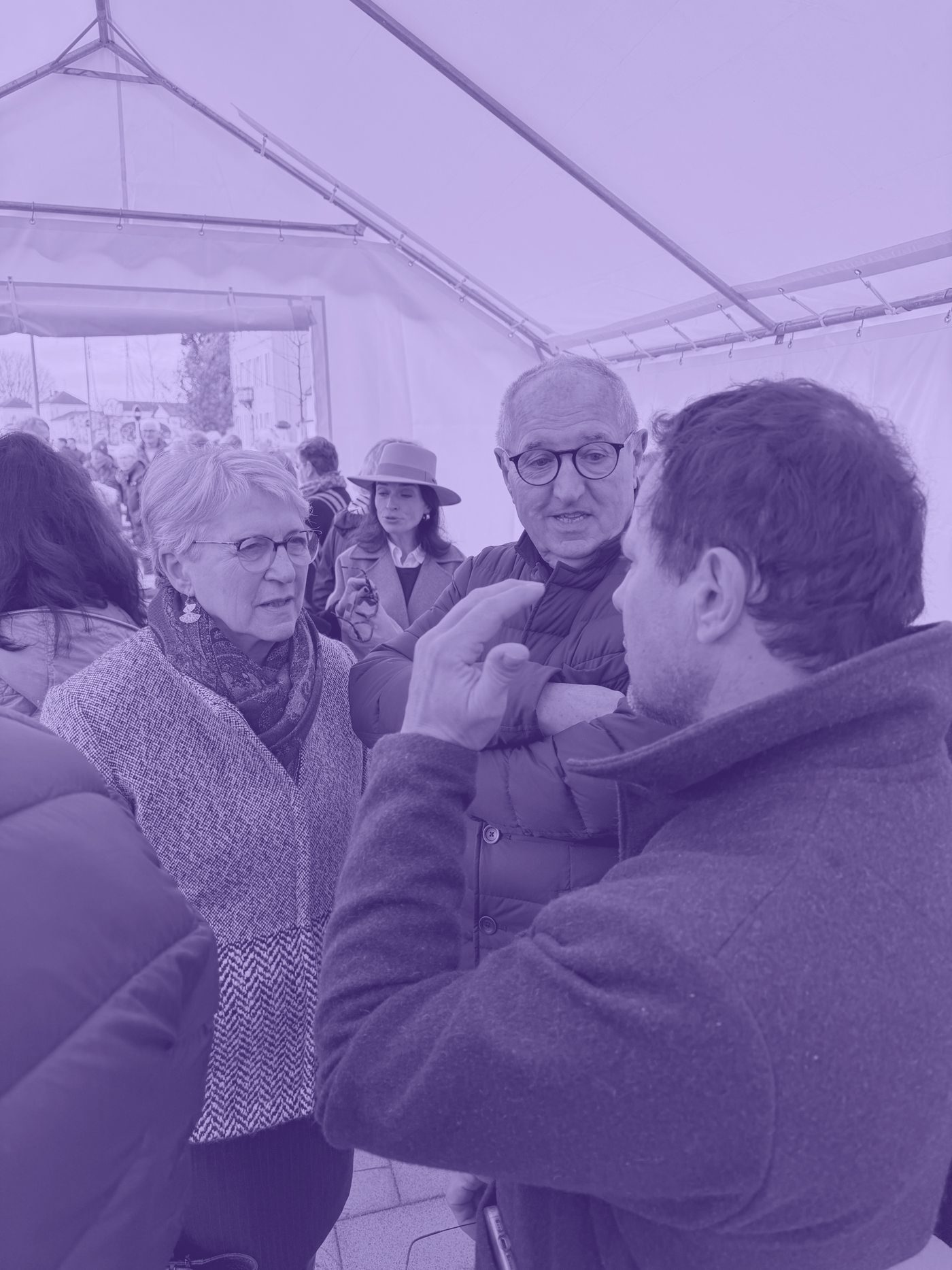 Paulette Matray échange avec des habitants sous un chapiteau lors d’une visite de terrain.
